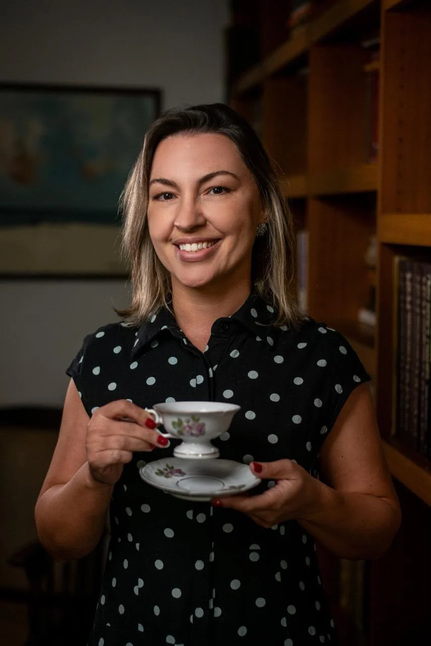 Rafaela Chaves com uma xícara de café na biblioteca